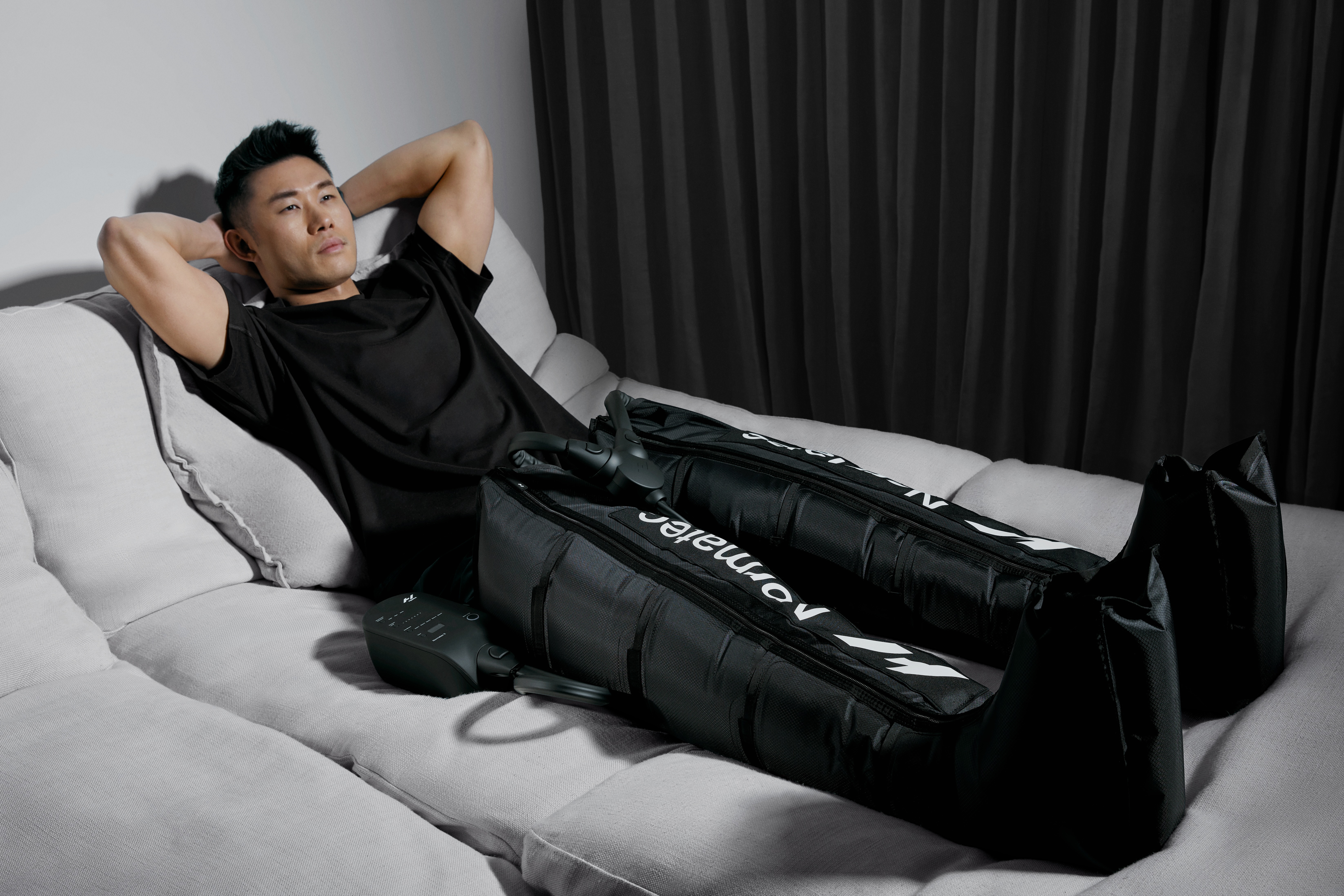 Man relaxing in Hyperice Normatec compression boots