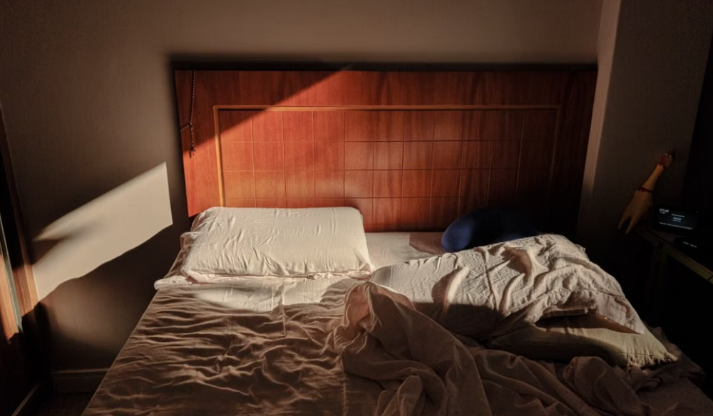 Unmade bed in low evening light