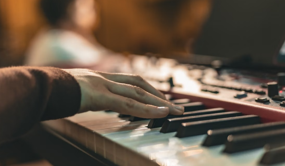 Hand adjusting faders on a mixing desk