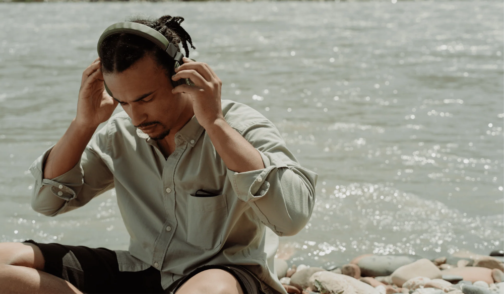 Man listening to music with headphones by the water