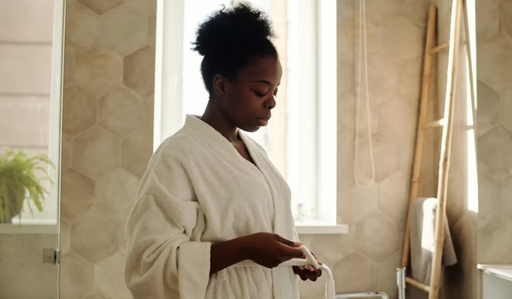Woman in a bathrobe in a tiled bathroom
