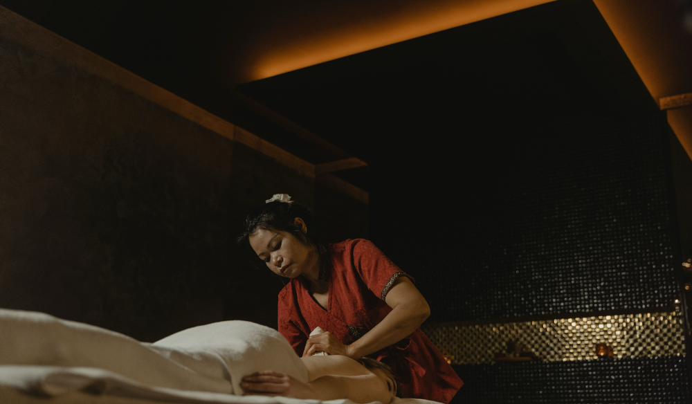 Therapist preparing a treatment in a dimly lit spa room