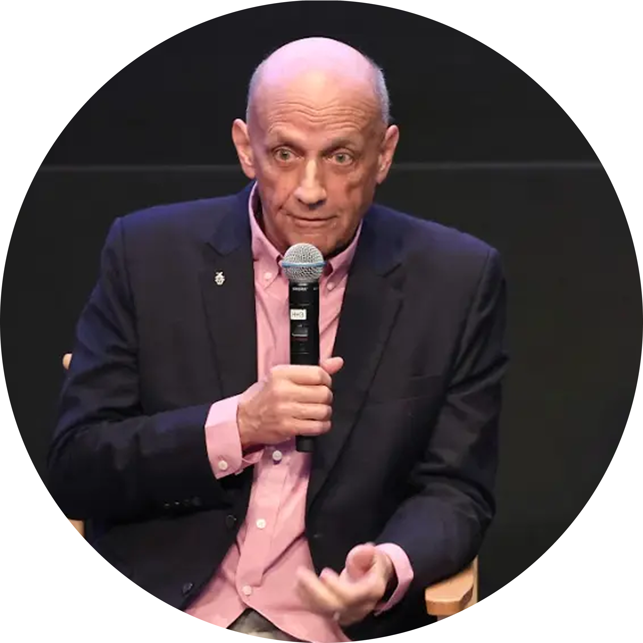 Man speaking with a microphone on stage
