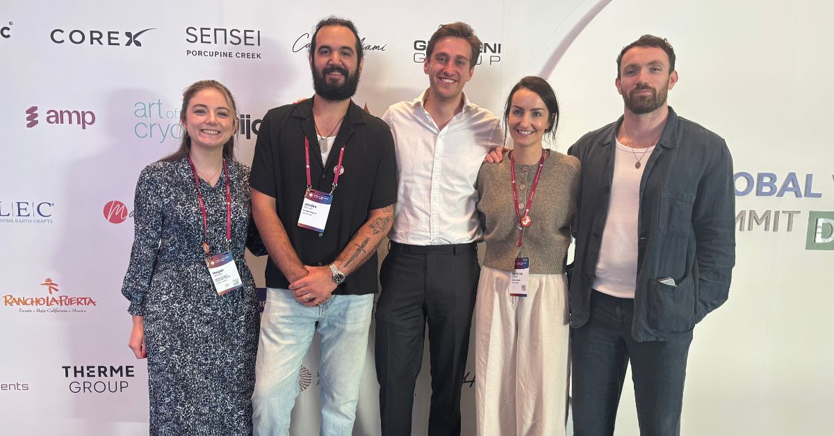 Myndstream team at a Global Wellness Summit sponsor wall