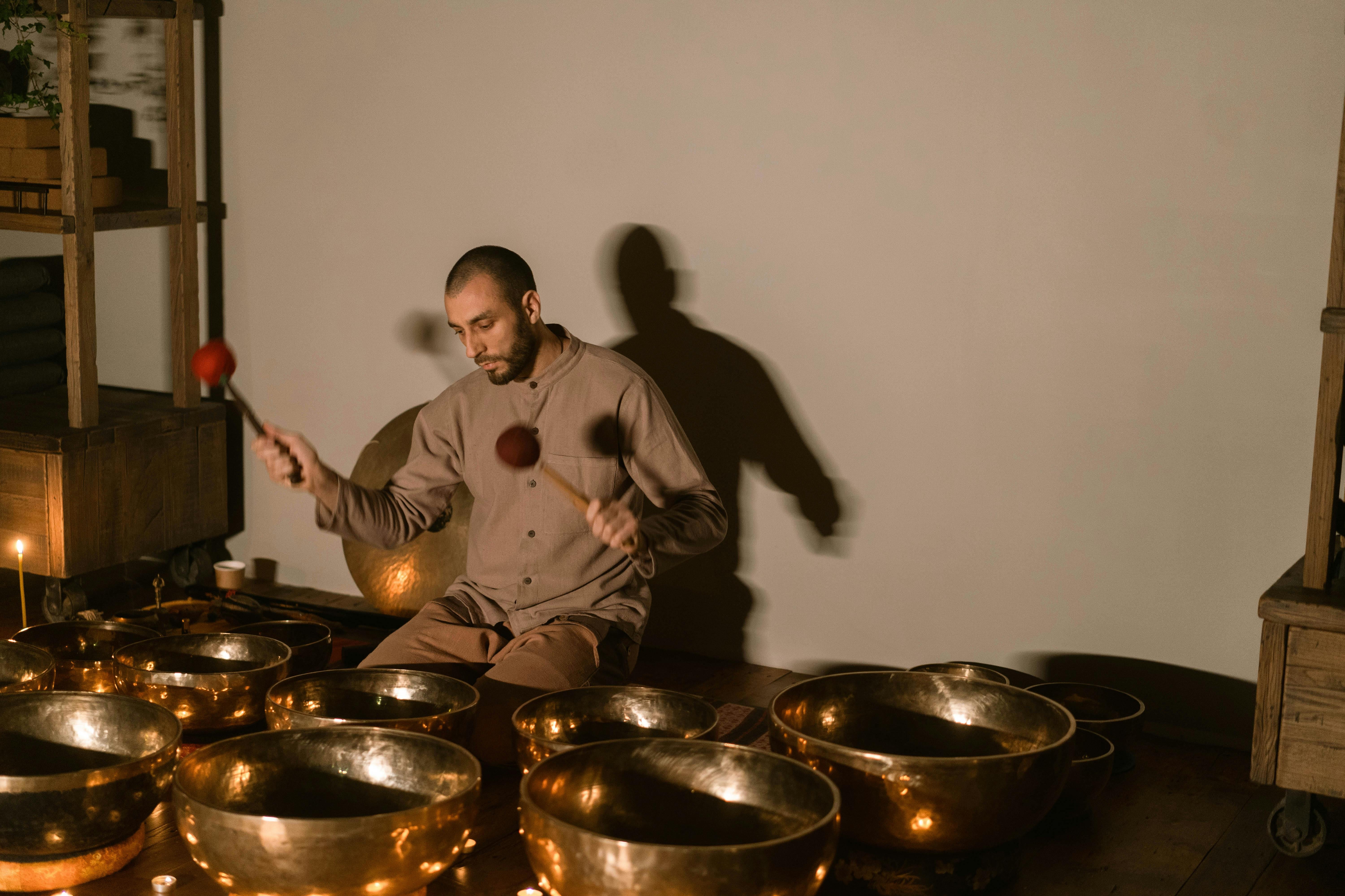 Musician playing singing bowls with mallets