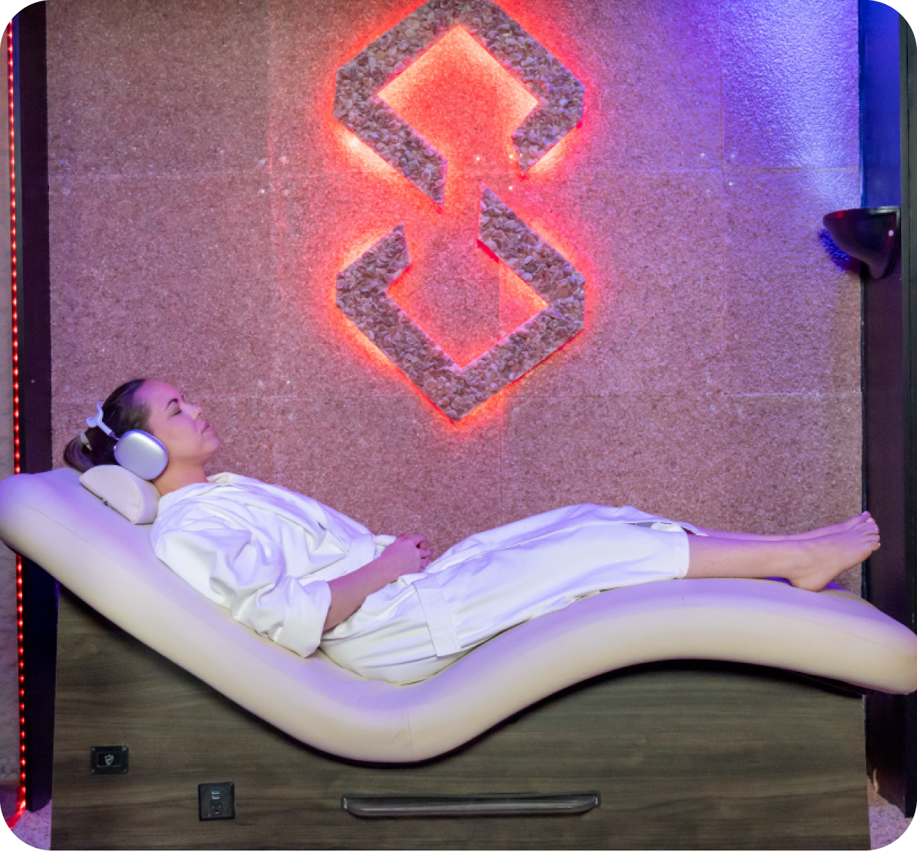 Guest reclining in a salt therapy room with a glowing salt wall